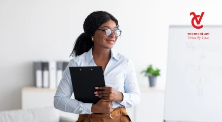 An established African female professional wearing glasses and holding a file at the office.